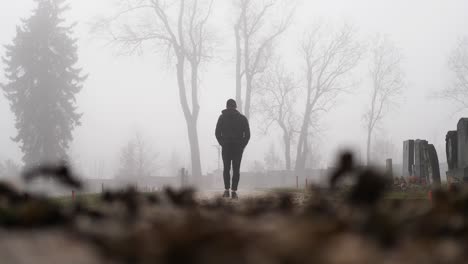 Slow-Motion-of-Man-Walking-in-Graveyard-in-Fog