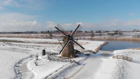 Traditional-winter-Dutch-snow-scene,-snowy-windmill-and-polder-landscape,-aerial