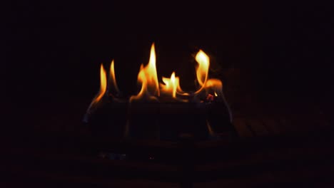 Burning-log-in-fireplace.-Black-background.-Looping