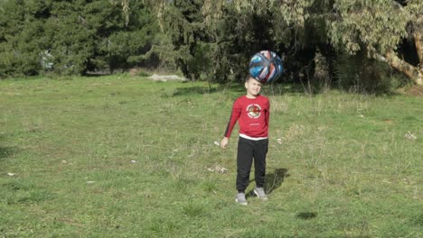 Slow-motion-shot-of-caucasian-boy-passing-small-size-basket-ball-towards-the-camera,-exercising-at-the-fields
