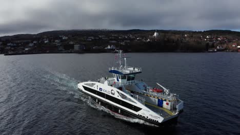 Aerial-shot-over-Electric-passenger-ferry-sailing-through-open-fjord---Norway