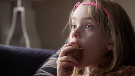 Little-girl-taking-a-big-bite-of-a-chocolate-egg-treat