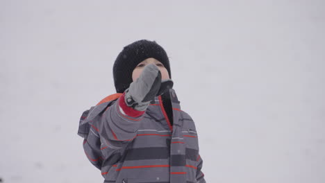 A-toddler-boy-looks-around-in-wonder-at-the-snow-falling