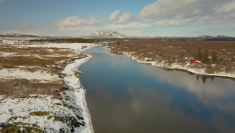 Filmdrohne-über-Dem-Olfusa-Fluss-In-Der-Nähe-Von-Selfoss,-Island,-Mit-Bergen-In-Der-Ferne