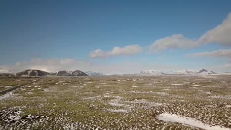 Cinematic-drone-shot-over-the-Iceland-landscape-near-Selfoss-with-mountains-in-the-distance