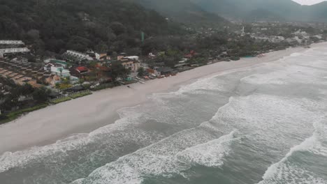 Drone-footage-of-the-beach-above-the-sea,-mountain-in-front-of-the-sea,-cloudy-day,-waves,-landscape-of-Juquehy,-Ubatuba,-northern-coast-of-São-Paulo,-Brazil