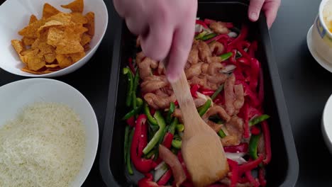 Mixing-Chicken-Breast-Fillet-With-Bell-Pepper-And-Onion-Strips-In-A-Baking-Tray