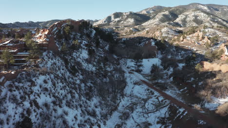 Aerial-dolly-forward-next-to-red-rock-ridge-covered-in-snow