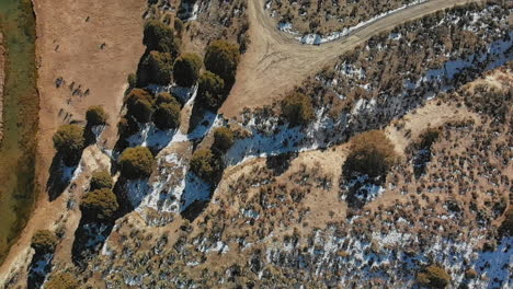 Tilt-up-from-East-Fork-Virgin-River-in-Utah-to-Small-Hamlet-in-Winter,-Aerial