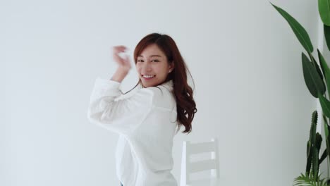 SLOW-MOTION-Lovely-Asian-woman-happy-dancing-with-glad-emotion-and-smiling-in-the-white-room