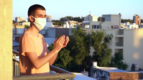 Junger-Mann-Mit-Maske-Applaudiert-Gesundheitspersonal-Vom-Balkon