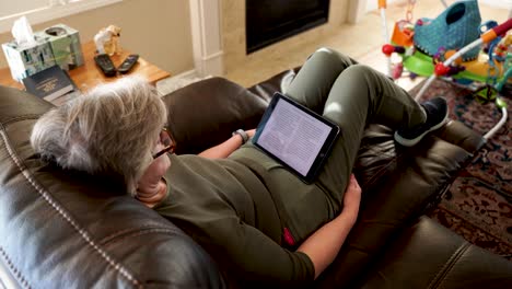 Looking-over-the-shoulder-of-a-mature-woman-reading-a-book-on-a-tablet