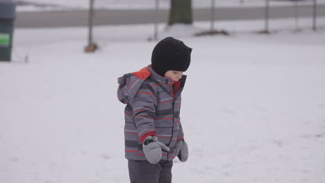 Little-boy-looks-in-wonder-at-the-freshly-fallen-snow
