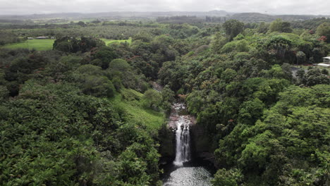 Slow-aerial-rise-over-lush-Hawaiian-jungle,-waterfall