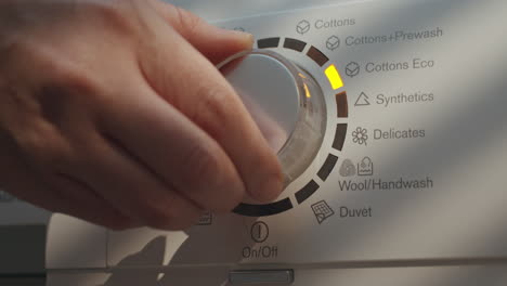 Laundry-Setting-Washing-Machine-Dial-to-ECO-Mode-for-Energy-Saving-and-Environmental-Conservation-in-Bathroom