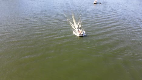 Pontoon-boat-approaching-drone-camera-at-full-speed
