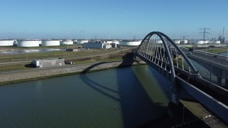 Railway-bridge-and-national-road-through-industrial-area-with-petroleum-storage-tanks