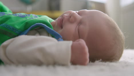 Closeup-shot-of-a-baby-smiling-and-stretching-while-sleeping-on-a-carpet