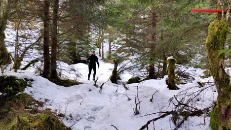 Girl-in-winter-clothes-running,-jumping-and-having-fun-through-the-forest-covered-in-white-snow-during-her-workout