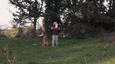 Niño-Caucásico-Caminando-Junto-Con-Su-Perro-Mascota-En-Un-Bosque-En-Parnitha,-Grecia-120fps