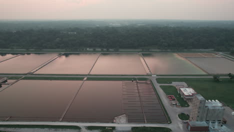 Aerial-trucking-shot-above-large-reservoirs-at-water-treatment-facility
