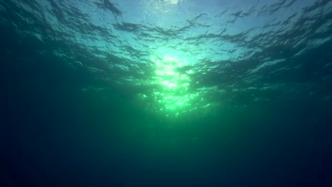 Rollende-Wellen-Und-Wasseroberfläche,-Die-Unter-Wasser-Gegen-Das-Licht-In-Einer-Tropischen-Ozeanumgebung-Geschossen-Werden