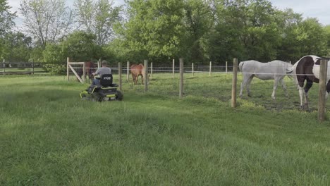 Man-Riding-An-Electric-Zero-Turn-Mower-Cutting-Overgrown-Grass-At-The-Ranch