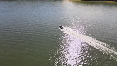 Pontoon-boat-driving-across-open-water-on-lake