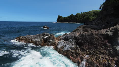 Niedrige-Fpv-drohnenüberführung-über-Ozeanwellen,-Die-Gegen-Die-Felsige-Hawaiianische-Küste-Prallen