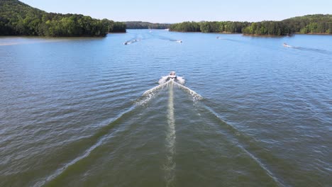 V-Hull-Ski-boat-moving-on-lake-as-camera-drone-approaches-and-passes-over