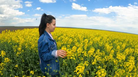 Girl-Walking-In-Amazing-Field-Of-Yellow-Rapeseed-In-The-Countryside---slow-motion