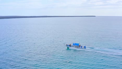 Weißes-Und-Blaues-Schnellboot-Mit-Touristen,-Die-Auf-Dem-Karibischen-Meer-Segeln