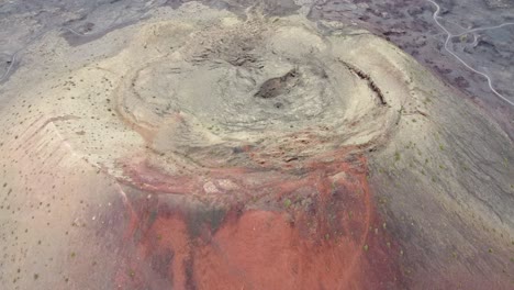 Aerial-drone-footage-of-a-huge-red-volcano-and-a-solitary-road-in-Canary-islands,-Spain
