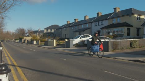 Man-cycling-along-quiet-road-with-shopping-bags