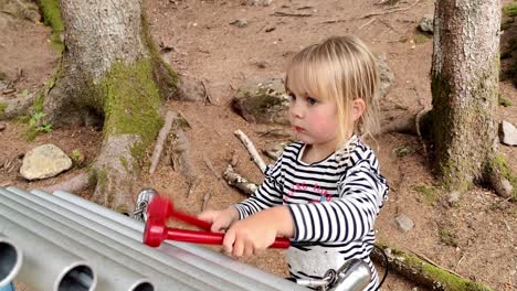 Cute-young-girl-having-a-good-time-playing-huge-xylophone-outdoors-in-theeme-park---Handheld-static---Mikkelparken-Norway