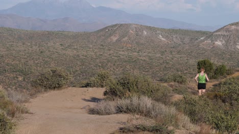 Woman-runs-down-a-trail-in-the-desert-with-a-green-leotard