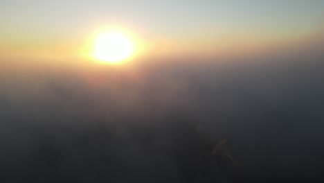 Die-Kamera-Steigt-Durch-Nebelwolken,-Um-Den-Sonnenaufgang-Zu-Enthüllen