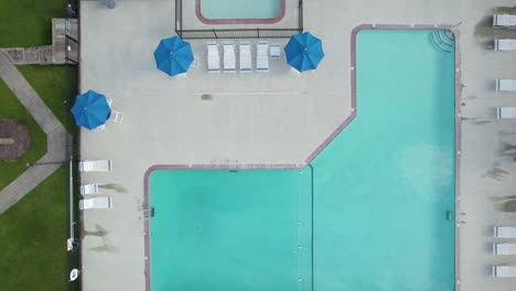 Downward-angle-drone-shot-of-swimming-pool-at-hotel-or-resort