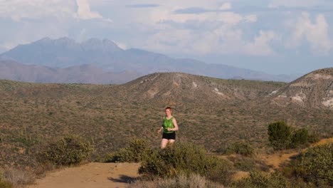 Runner-in-the-mountains-of-Arizona-on-a-dirt-trail-wearing-a-green-leotard-and-black-shorts