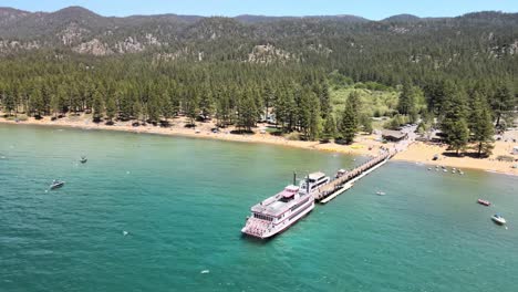 MS-Dixie-ll-ferry-boat-on-the-dock-as-a-drone-flies-counter-clockwise-from-the-back-of-the-ferry-to-the-front-with-north-Lake-Tahoe-as-the-background