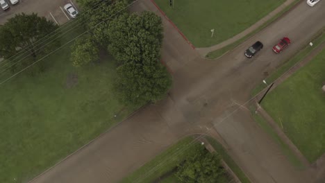 From-a-birds-eye-view-cars-slowly-pass-each-other-on-a-flash-flooded-neighborhood-street-intersection