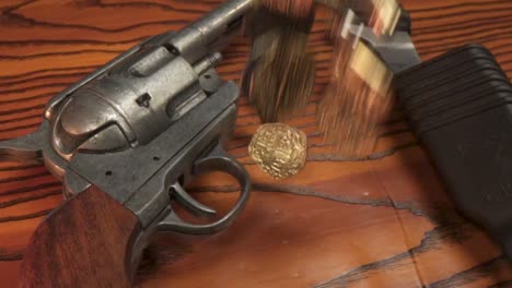 Gold-coins-falling-onto-wood-with-gun-and-knife