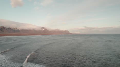 Low-flyover-above-rugged-coastline-of-Iceland-at-sunset