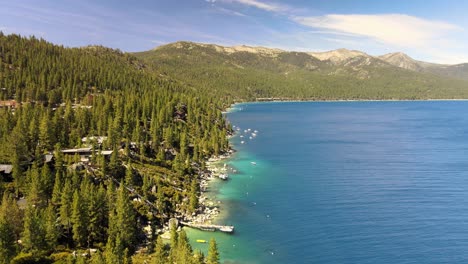 Drone-flying-above-surrounding-terrain-to-reveal-stunning-shoreline-along-North-Lake-Tahoe
