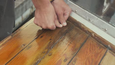Man-checking-soft-timber-planks-affected-by-wood-rot