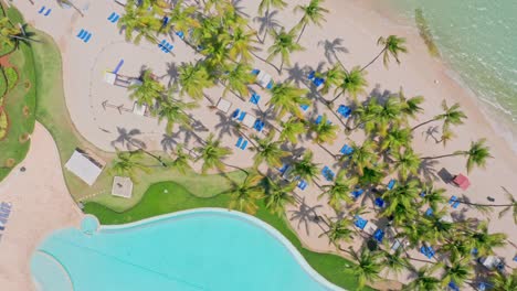 Swimming-Pool-At-Beach-Hotel-With-Palm-Trees-On-A-Sunny-Summer-Day-In-Juan-Dolio,-Dominican-Republic