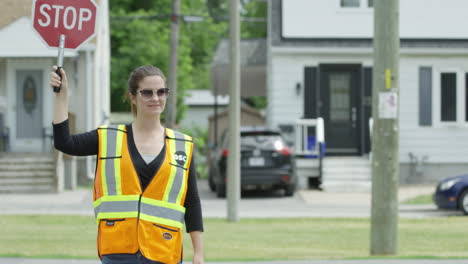 Tilt-up-to-female-crossing-guard-walking-across-the-street
