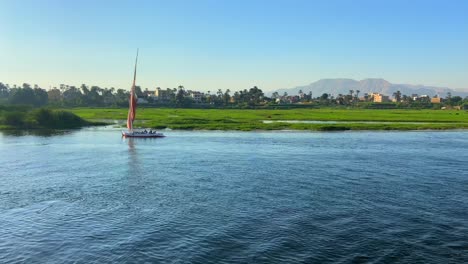 Luftdrohnenvideo-Einer-Idyllischen-Reise-Durch-Die-Nilufer-Eines-Segelboots,-Das-Bei-Sonnenuntergang-Navigiert