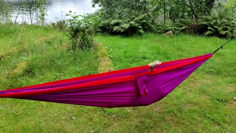 Funny-clip-of-young-girl-playing-around-inside-purple-hammock---Handheld-outdoor-in-nature