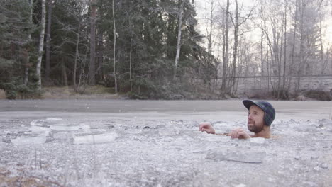 A-rugged-bearded-ice-bather-sits-in-his-ice-hole-in-a-Swedish-lake